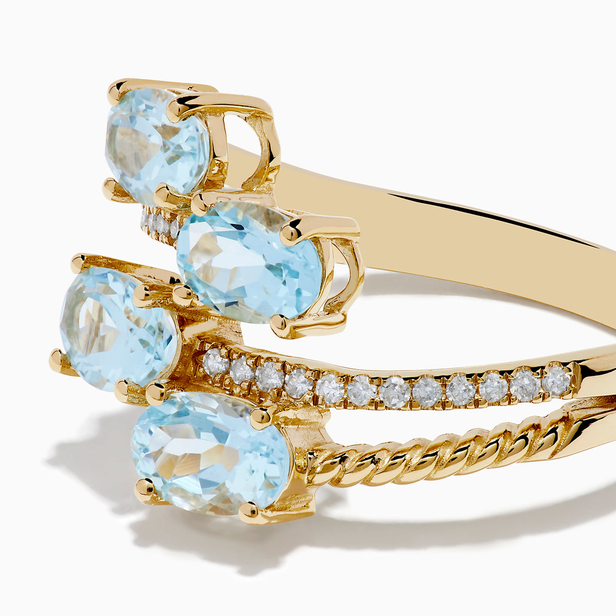 The Aquarius 14K Yellow Gold Aquamarine and Diamond Bypass Ring features two overlapping bands with sparkling diamonds and four diagonally set oval aquamarines.