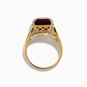 The Bordeaux 14K Yellow Gold Garnet and Diamond Ring showcases a large cushion-cut deep red garnet centered on an intricately designed band with sparkling diamond accents.