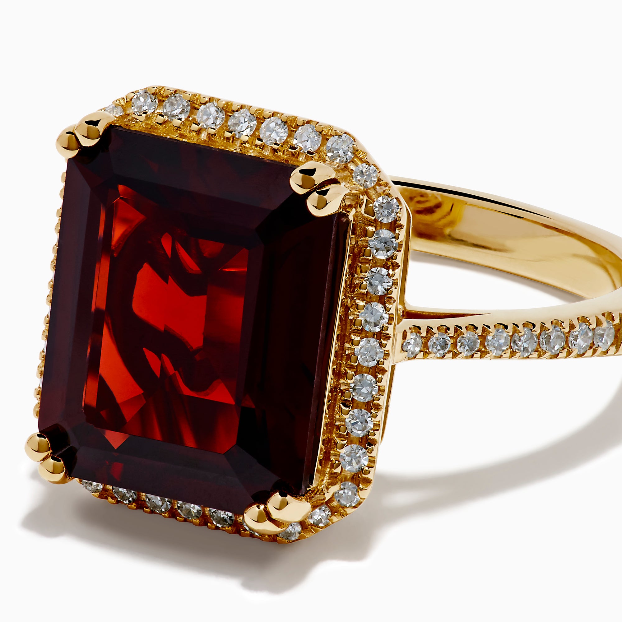 The 14K Yellow Gold Garnet and Diamond Halo Cocktail Ring showcases a large rectangular deep red garnet, surrounded by a diamond halo and diamonds on the band, set against a white background.