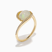 The 14K Yellow Gold Ethiopian Opal and Diamond Swirl Ring showcases a striking Ethiopian opal set in yellow gold, complemented by a swirling band adorned with sparkling diamonds.