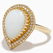 The 14K Yellow Gold Pear Shaped Opal and Diamond Cocktail Ring features a large pear-shaped opal framed by two rows of sparkling diamonds, displayed on a plain white background.