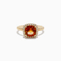 The 14K Yellow Gold Citrine and Diamond Ring showcases a cushion-cut orange citrine at the center, encircled by a halo of diamonds on a textured yellow gold band, elegantly displayed against a white background.