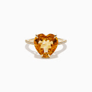 The Sunset 14K Yellow Gold Citrine and Diamond Heart Ring features a large heart-shaped citrine gemstone at the center, accented by small diamonds on the band, and is pictured against a white background.