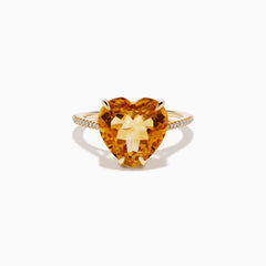 The Sunset 14K Yellow Gold Citrine and Diamond Heart Ring features a large heart-shaped citrine gemstone at the center, accented by small diamonds on the band, and is pictured against a white background.