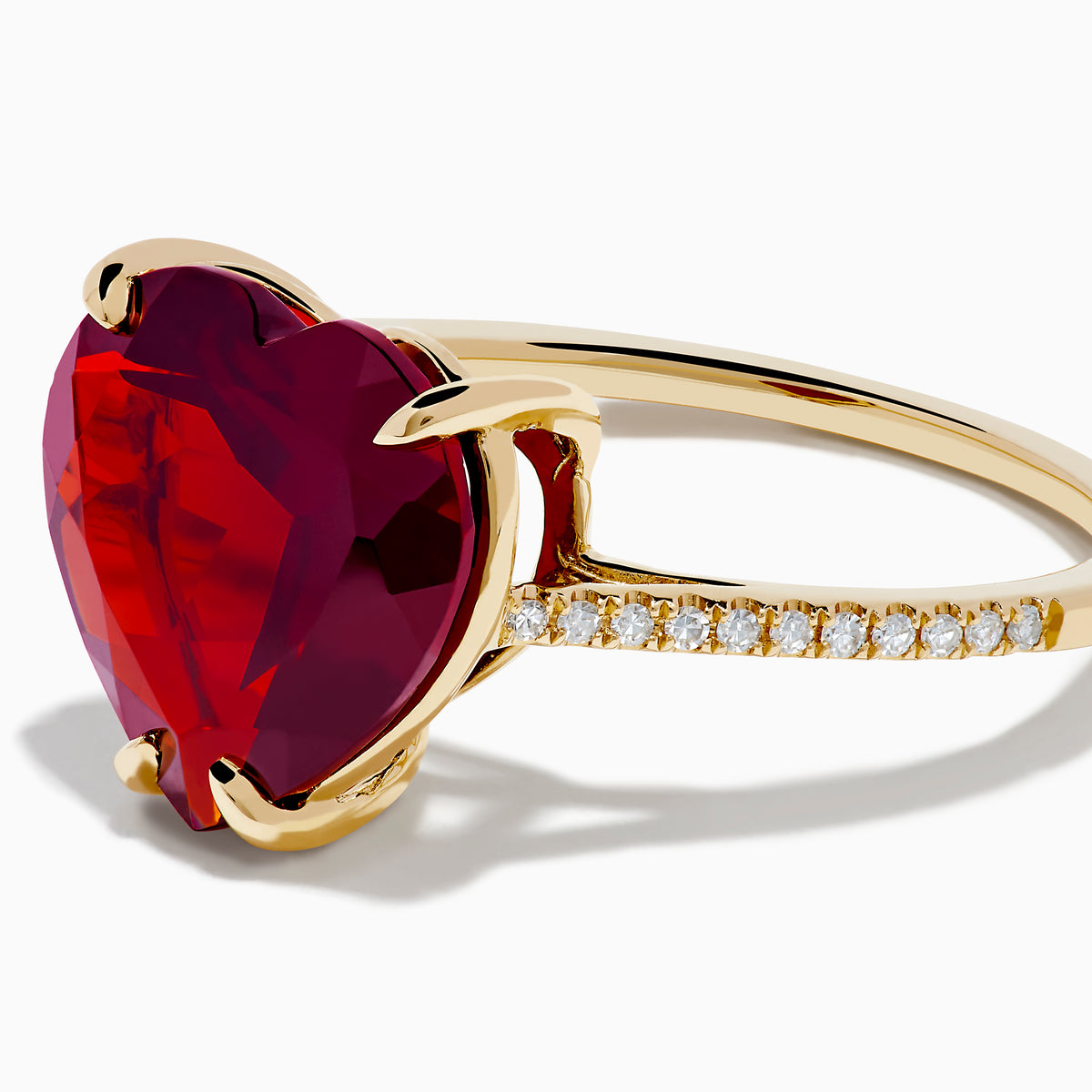 The Bordeaux 14K Yellow Gold Garnet and Diamond Heart Ring features a large heart-shaped deep red garnet at the center with small diamonds on the band, shown against a white background.