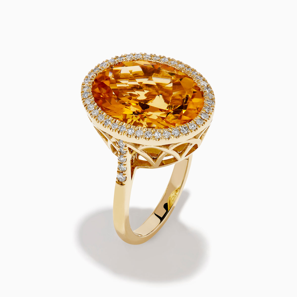 The Sunset 14K Yellow Gold Citrine and Diamond Halo Ring showcases a large oval citrine center stone encircled by a sparkling diamond halo, elegantly displayed on a plain white background.