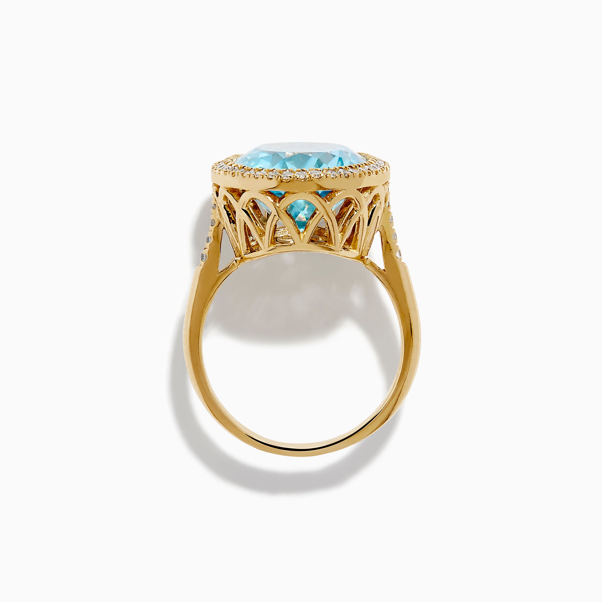 The 14K Yellow Gold Blue Topaz and Diamond Halo Cocktail Ring showcases a large oval blue topaz gemstone surrounded by sparkling diamonds, presented against a simple white background.