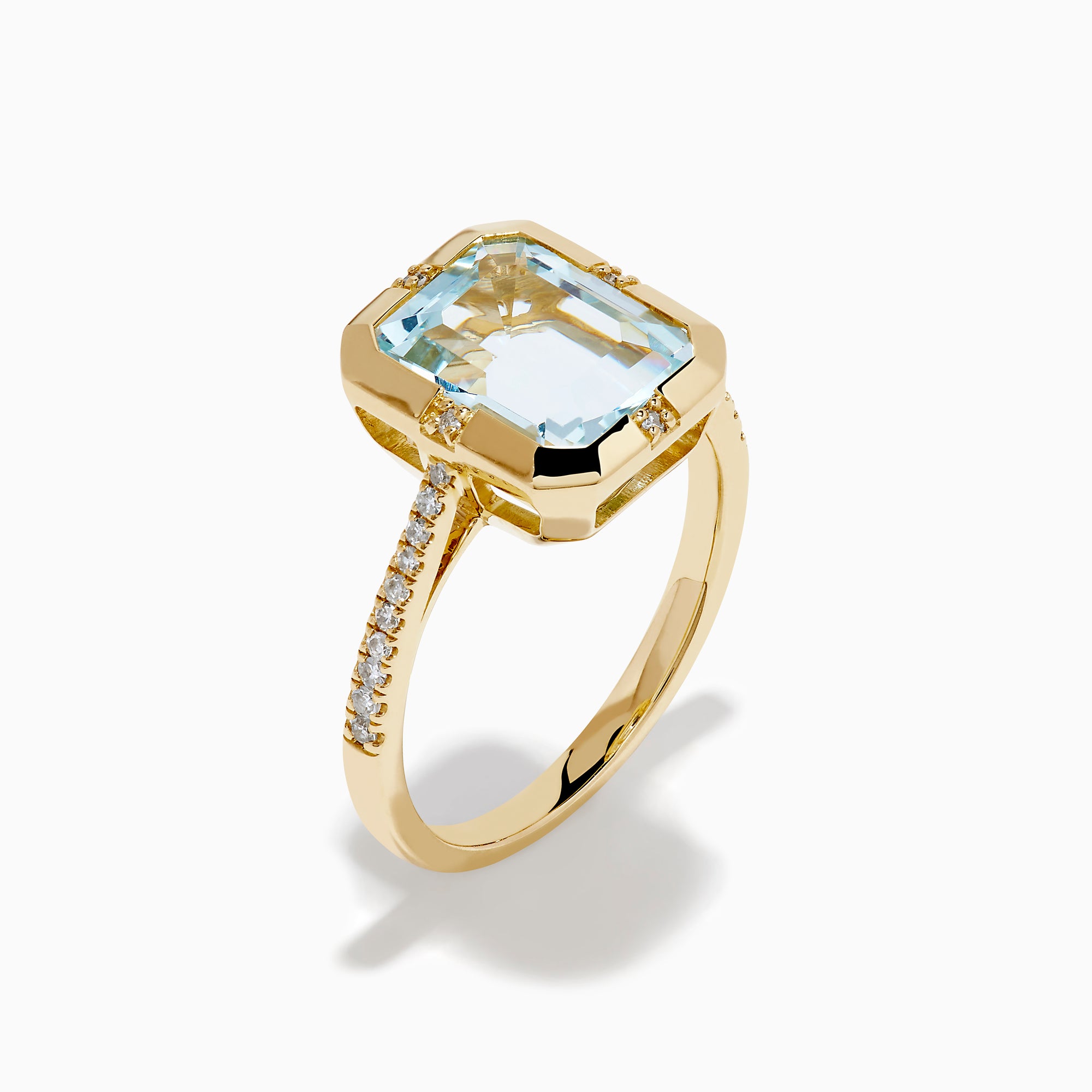 The 14K Yellow Gold Aquamarine and Diamond Bezel Solitaire Ring showcases an emerald-cut light blue aquamarine center stone with diamond accents on the band, displayed against a white background.