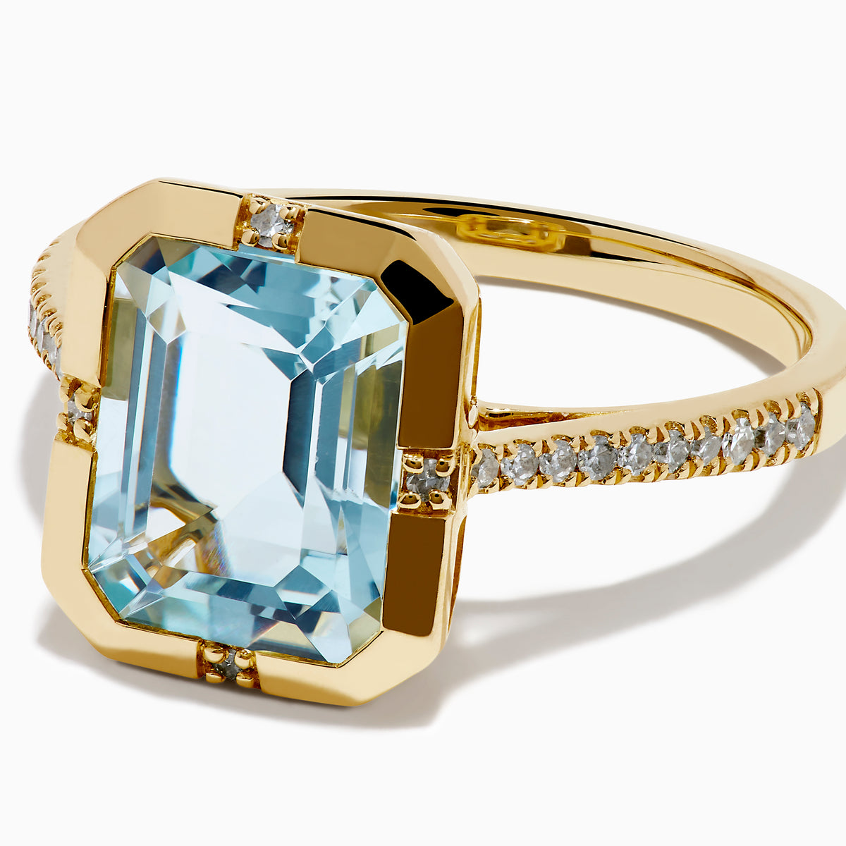 The 14K Yellow Gold Aquamarine and Diamond Bezel Solitaire Ring showcases an emerald-cut light blue aquamarine center stone with diamond accents on the band, displayed against a white background.