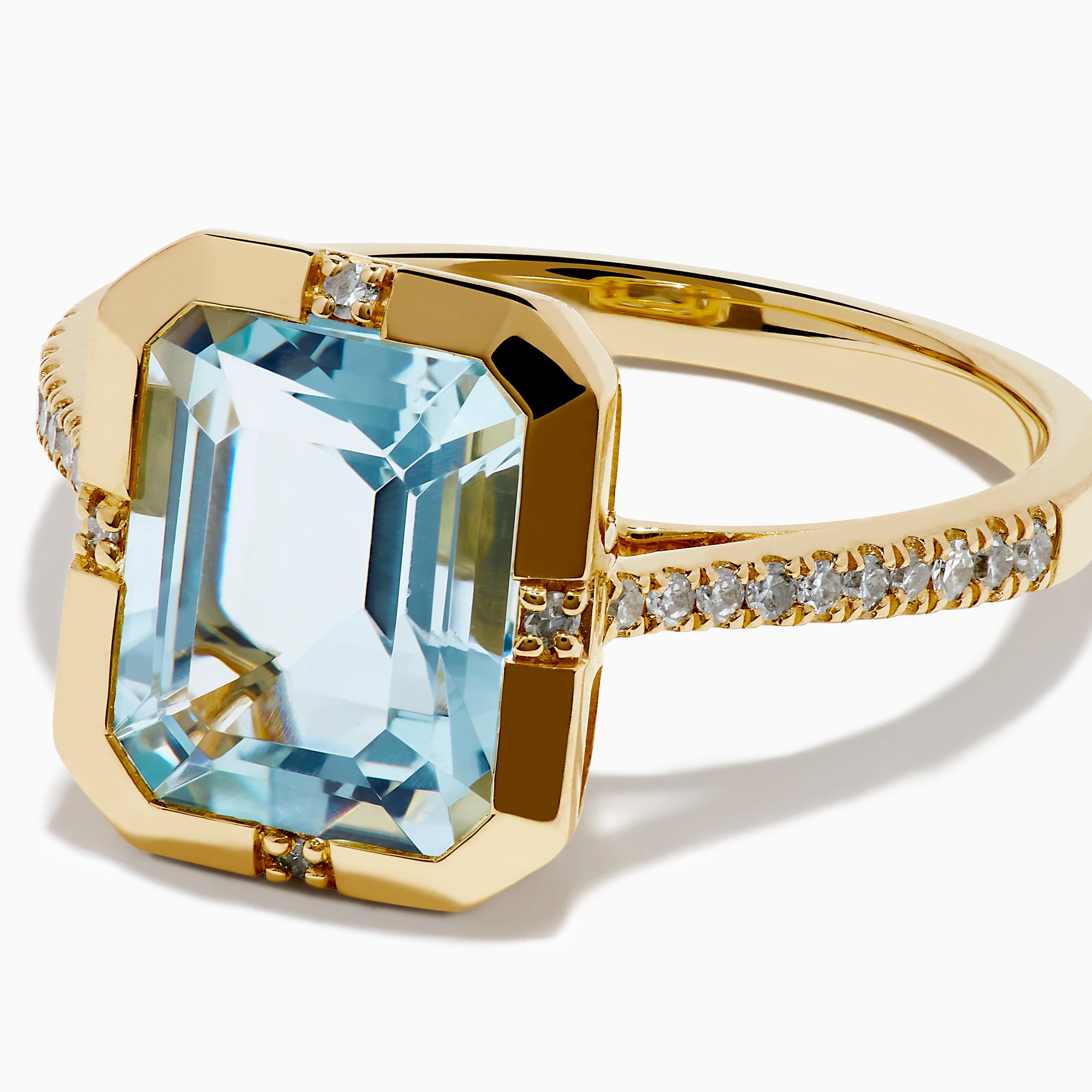 The 14K Yellow Gold Aquamarine and Diamond Bezel Solitaire Ring showcases an emerald-cut light blue aquamarine center stone with diamond accents on the band, displayed against a white background.