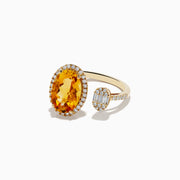 The Sunset 14K Yellow Gold Citrine and Diamond Ring features a large oval citrine framed by diamonds and a smaller baguette diamond cluster, both set on a slim yellow gold band against a white background.