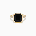 The 14K Yellow Gold Bezel Set Black Onyx and Diamond Ring features a bold square-cut black onyx center stone and sparkling diamonds set along the band.