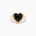 The 14K Yellow Gold Onyx and Diamond Heart Ring features a heart-shaped black onyx centerpiece bordered by sparkling diamonds, creating a romantic and elegant look.