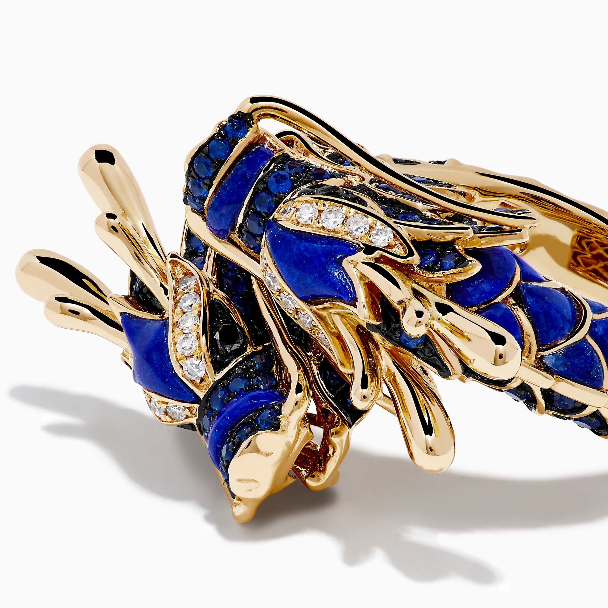 The Safari 14K Yellow Gold Diamond, Lapis and Sapphire Dragon Ring, shaped as a dragon’s head and body, features blue enamel scales and sparkling gemstones, evoking the fierce beauty of a sapphire dragon ring on a white background.