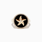 The Seaside 14K Yellow Gold Black Agate and Diamond Starfish Ring features a round black agate face, a gold starfish with a central diamond, and a border of small diamonds on the edge.