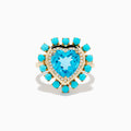 The 14K Yellow Gold Blue Topaz, Turquoise and Diamond Heart Cocktail Ring features a striking heart-shaped blue topaz center, surrounded by a halo of diamonds and an outer border of vibrant round turquoise stones.