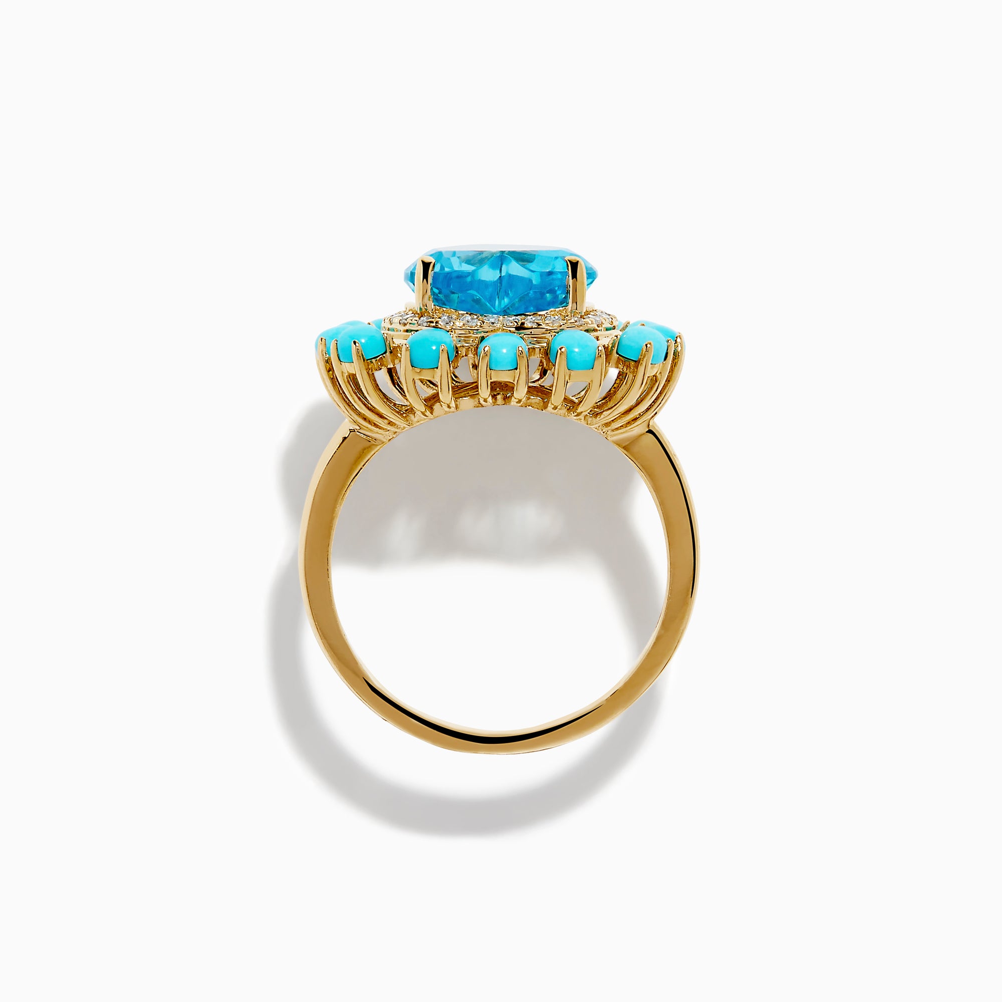 The 14K Yellow Gold Blue Topaz, Turquoise and Diamond Heart Cocktail Ring features a striking heart-shaped blue topaz center, surrounded by a halo of diamonds and an outer border of vibrant round turquoise stones.