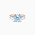 The Aquarius 14K Rose and White Gold Aquamarine and Diamond Ring features a large round aquamarine center, surrounded by a halo of sparkling diamonds with additional diamonds along the band.