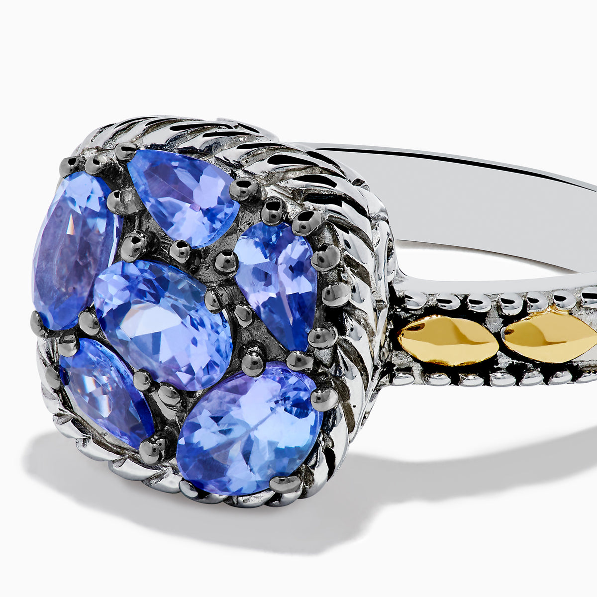 The 925 Sterling Silver and 18K Yellow Gold Tanzanite Ring features intricate rope detailing and a cluster of five marquise and oval blue gemstones, highlighted by yellow gold accents along the band.