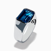 The Mens Ocean Bleu 925 Sterling Silver London Blue Topaz Ring features a large, emerald-cut rectangular gemstone set in the center, showcased against a plain white background.