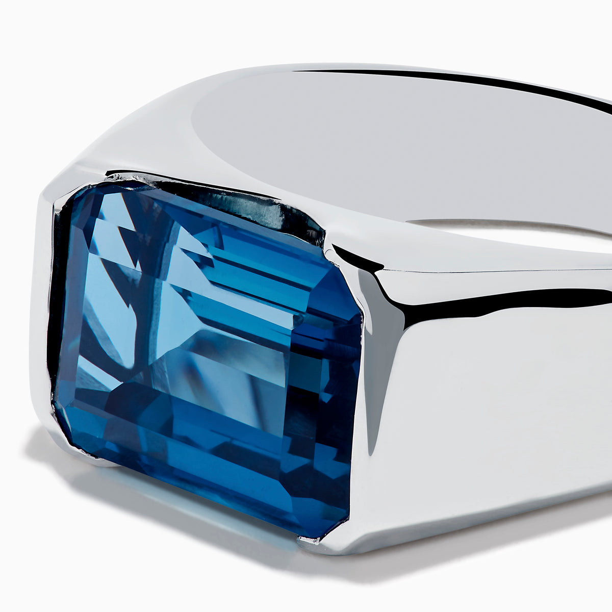 The Mens Ocean Bleu 925 Sterling Silver London Blue Topaz Ring features a large, emerald-cut rectangular gemstone set in the center, showcased against a plain white background.