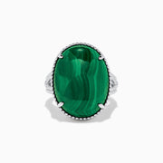 The 925 Sterling Silver Malachite Oval Ring showcases a large, oval green malachite stone with natural banding, set in four prongs and finished with decorative bead accents for a striking look.