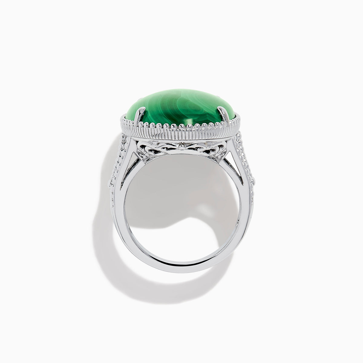 The 925 Sterling Silver Malachite Oval Ring showcases a large, oval green malachite stone with natural banding, set in four prongs and finished with decorative bead accents for a striking look.