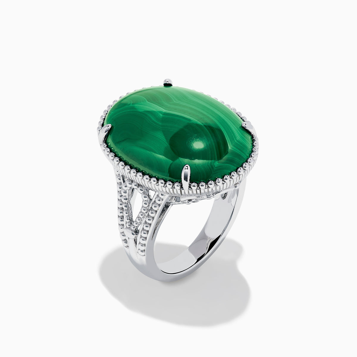 The 925 Sterling Silver Malachite Oval Ring showcases a large, oval green malachite stone with natural banding, set in four prongs and finished with decorative bead accents for a striking look.