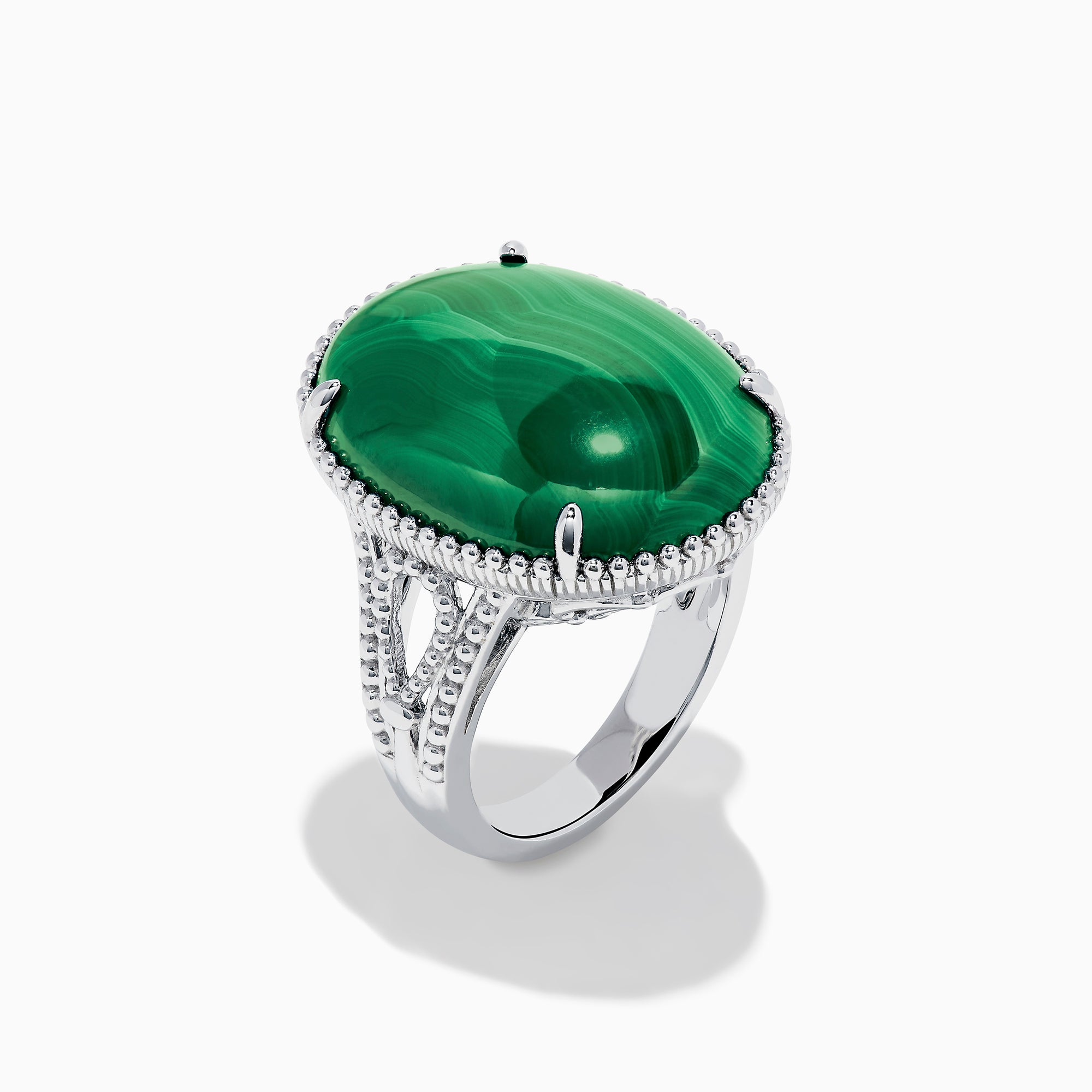 The 925 Sterling Silver Malachite Oval Ring showcases a large, oval green malachite stone with natural banding, set in four prongs and finished with decorative bead accents for a striking look.