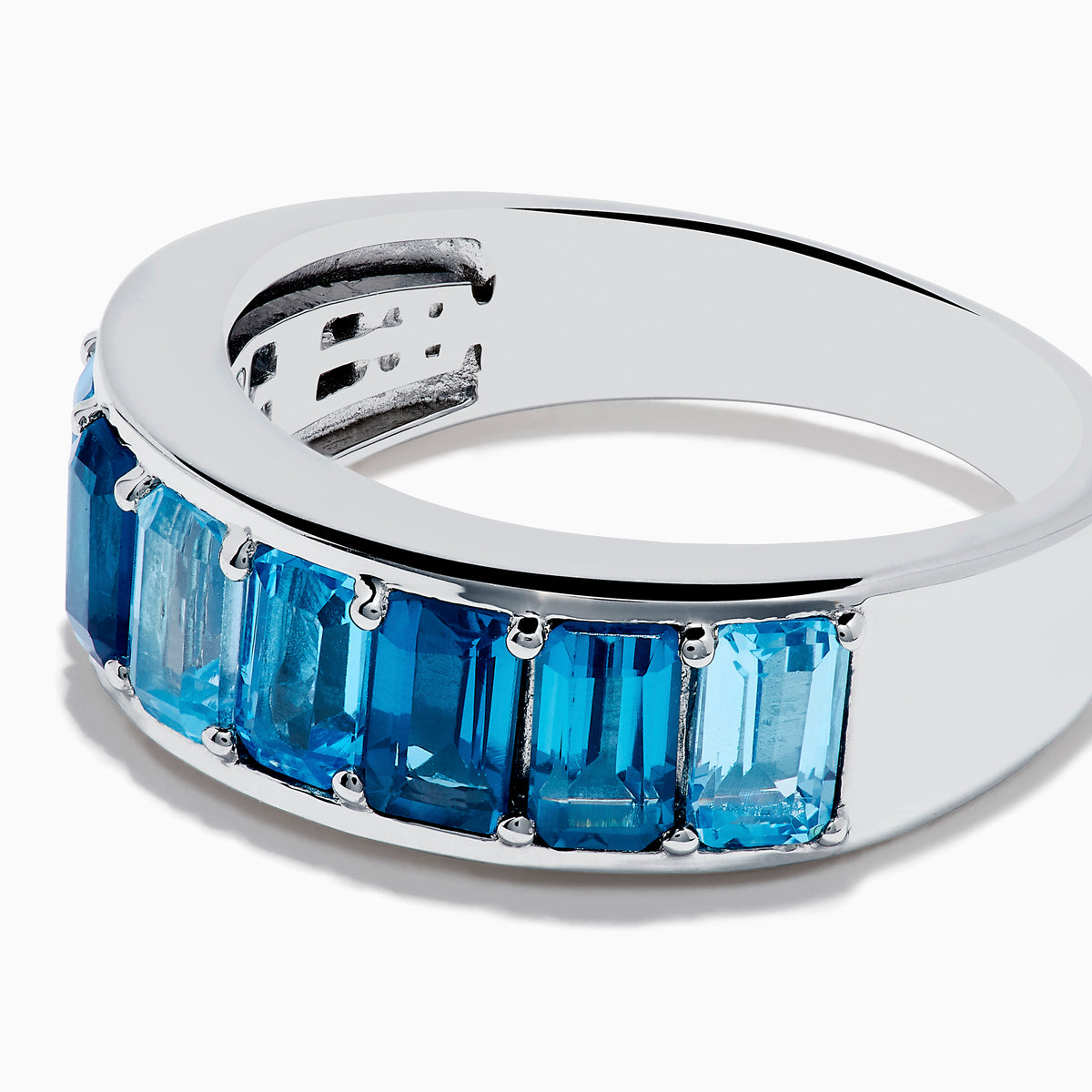 The Ocean Bleu 925 Sterling Silver Blue Topaz Ring features a continuous band of rectangular blue topaz gemstones in varying shades, set side by side, and is displayed against a plain white background.