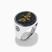The Men's Sterling Silver Black Spinel Moth Ring showcases a gold moth and crescent moon on a round navy face, accented with sparkling black spinel stones.