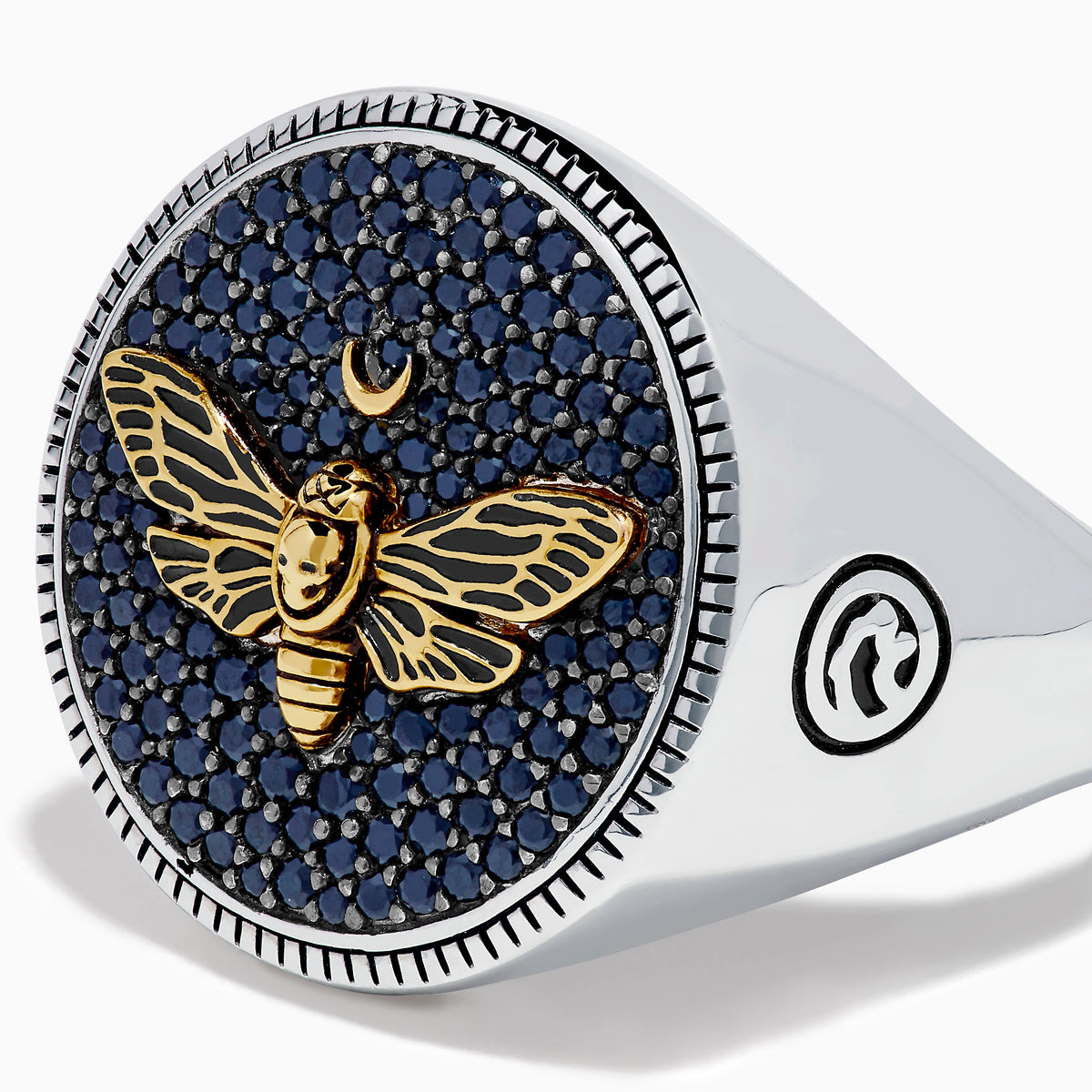 The Men's Sterling Silver Black Spinel Moth Ring showcases a gold moth and crescent moon on a round navy face, accented with sparkling black spinel stones.