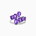 The 925 Sterling Silver Amethyst Bypass Ring showcases seven faceted purple gemstones of assorted shapes and sizes set in a sleek, modern open design against a plain white background.