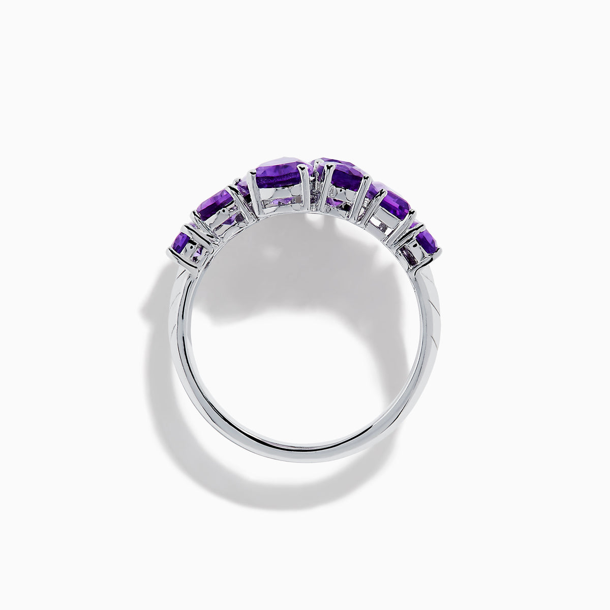 The 925 Sterling Silver Amethyst Bypass Ring showcases seven faceted purple gemstones of assorted shapes and sizes set in a sleek, modern open design against a plain white background.