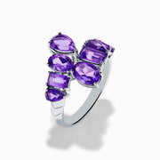 The 925 Sterling Silver Amethyst Bypass Ring showcases seven faceted purple gemstones of assorted shapes and sizes set in a sleek, modern open design against a plain white background.