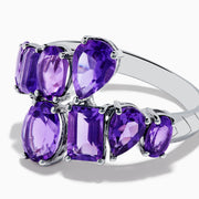 The 925 Sterling Silver Amethyst Bypass Ring showcases seven faceted purple gemstones of assorted shapes and sizes set in a sleek, modern open design against a plain white background.
