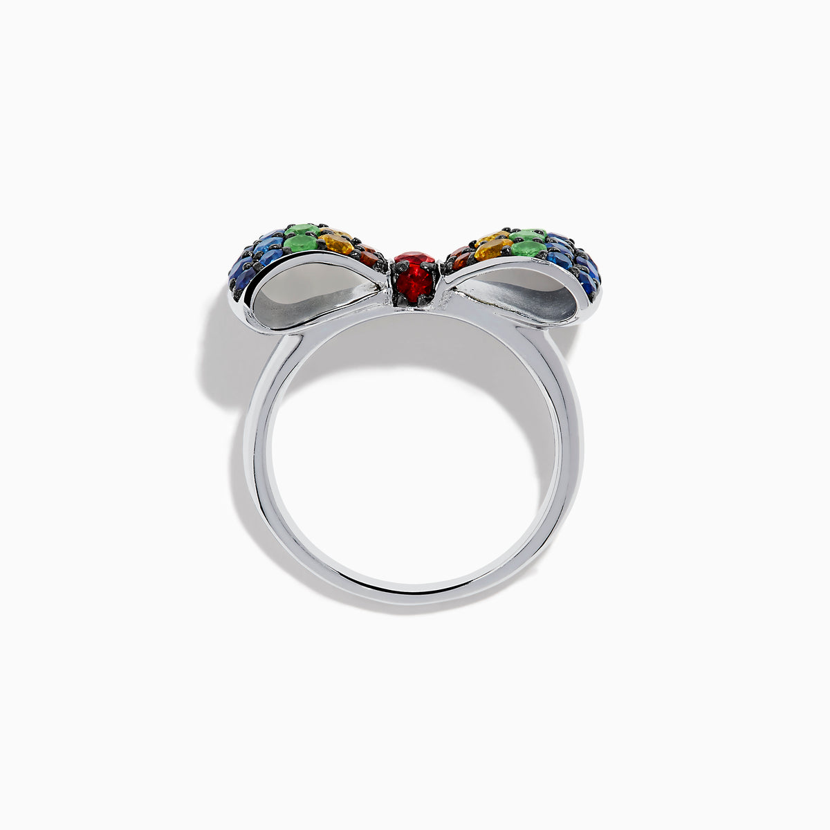 The Safari 925 Sterling Silver Multi Color Sapphire Bow Ring features red, yellow, green, and blue sapphires arranged symmetrically in a bow design against a white background.