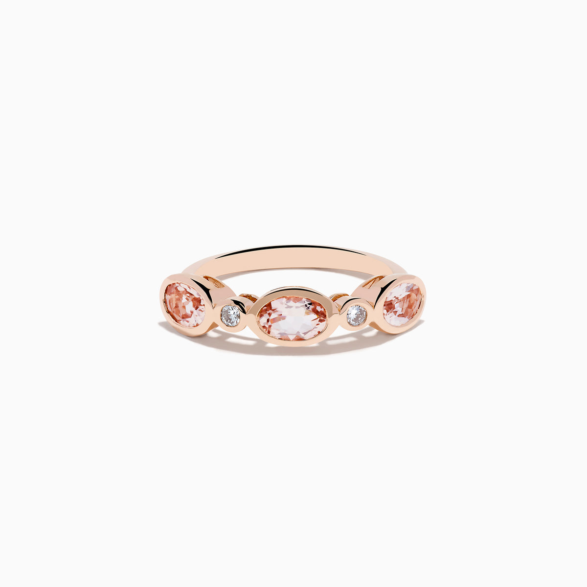 The 14K Rose Gold Morganite and Diamond Band Ring showcases three oval morganite stones and two round diamonds set symmetrically, all elegantly displayed against a white background.