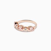 The 14K Rose Gold Morganite and Diamond Band Ring showcases three oval morganite stones and two round diamonds set symmetrically, all elegantly displayed against a white background.