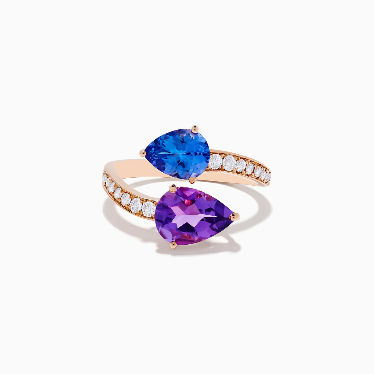 The 14K Rose Gold Amethyst, Tanzanite and Diamond Ring showcases a modern open band set with pear-shaped blue tanzanite, purple amethyst, and small round diamonds for an elegant look.