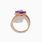 The 14K Rose Gold Amethyst, Tanzanite and Diamond Ring showcases a modern open band set with pear-shaped blue tanzanite, purple amethyst, and small round diamonds for an elegant look.