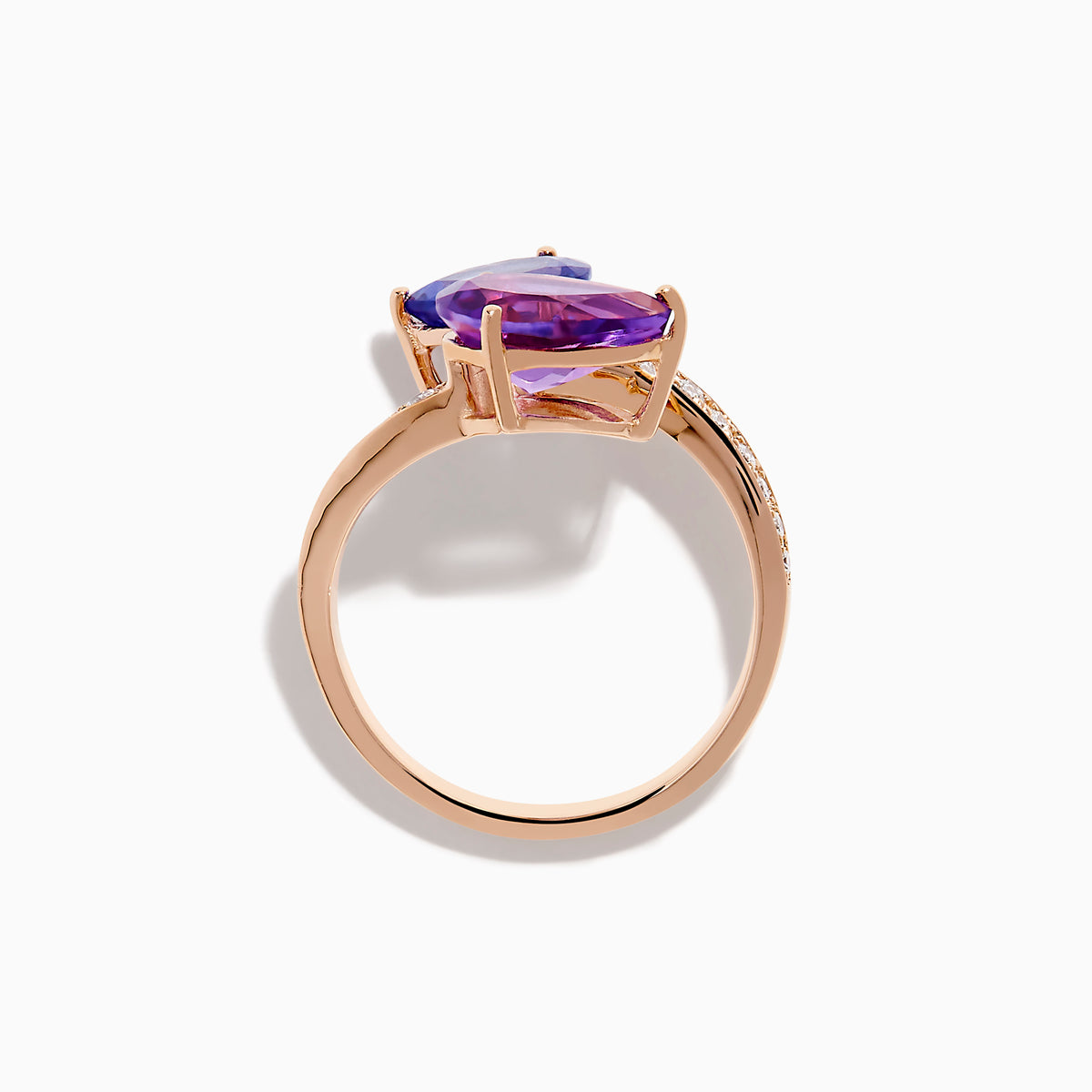 The 14K Rose Gold Amethyst, Tanzanite and Diamond Ring showcases a modern open band set with pear-shaped blue tanzanite, purple amethyst, and small round diamonds for an elegant look.