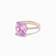 The 14K Rose Gold Kunzite and Diamond Ring features a large oval-cut kunzite center stone accented by sparkling diamonds along the band.