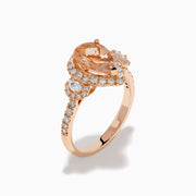 The 14K Rose Gold Pear Morganite and Diamond Halo Ring showcases a peach-hued pear morganite with sparkling diamond halo and accents, all set in 14K rose gold, against a white background.