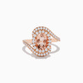 The 14K Rose Gold Morganite and Diamond Ring features an oval peach morganite center, encircled by a halo of white diamonds, all set on a swirling diamond-encrusted band.