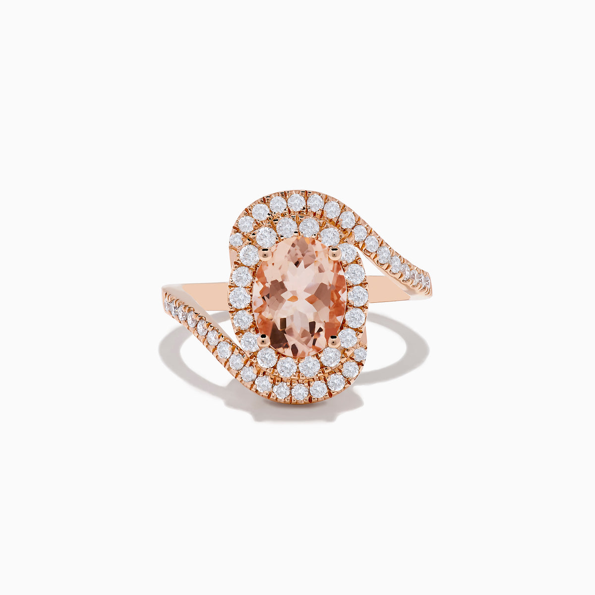 The 14K Rose Gold Morganite and Diamond Ring features an oval peach morganite center, encircled by a halo of white diamonds, all set on a swirling diamond-encrusted band.