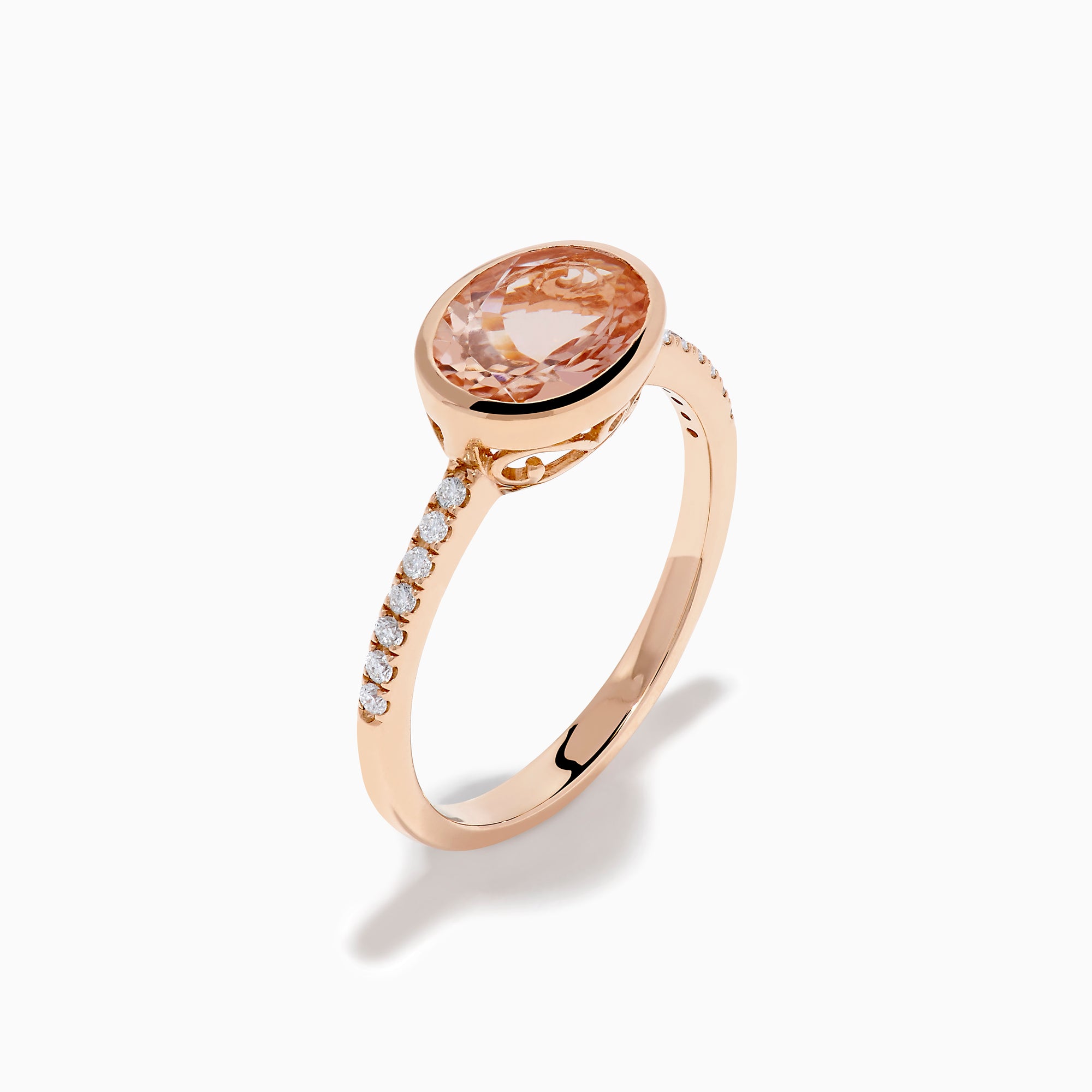 The 14K Rose Gold Morganite and Diamond East West Bezel Ring showcases a striking round peach morganite center stone with small diamonds along the band, set against a white background.
