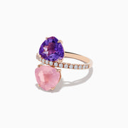The 14K Rose Gold Amethyst, Rose Quartz, and Diamond Toi Et Moi Ring features a band of small white diamonds with a large pear-shaped amethyst set above a pear-shaped rose quartz, both arranged vertically.