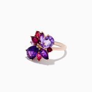 The 14K Rose Purple and Pink Amethyst, Rhodolite, and Pink Tourmaline Ring features a floral design with teardrop and marquise-shaped gemstones arranged as petals on a white background.