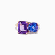 The 14k Rose Gold Amethyst and Tanzanite Toi Et Moi Ring features a rectangular purple amethyst and a cushion-cut blue tanzanite side by side on a minimalist band, displayed against a white background.